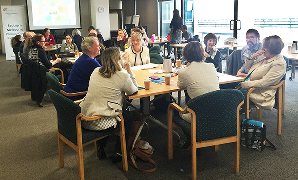 Image shows people sitting around tables discussing health planning