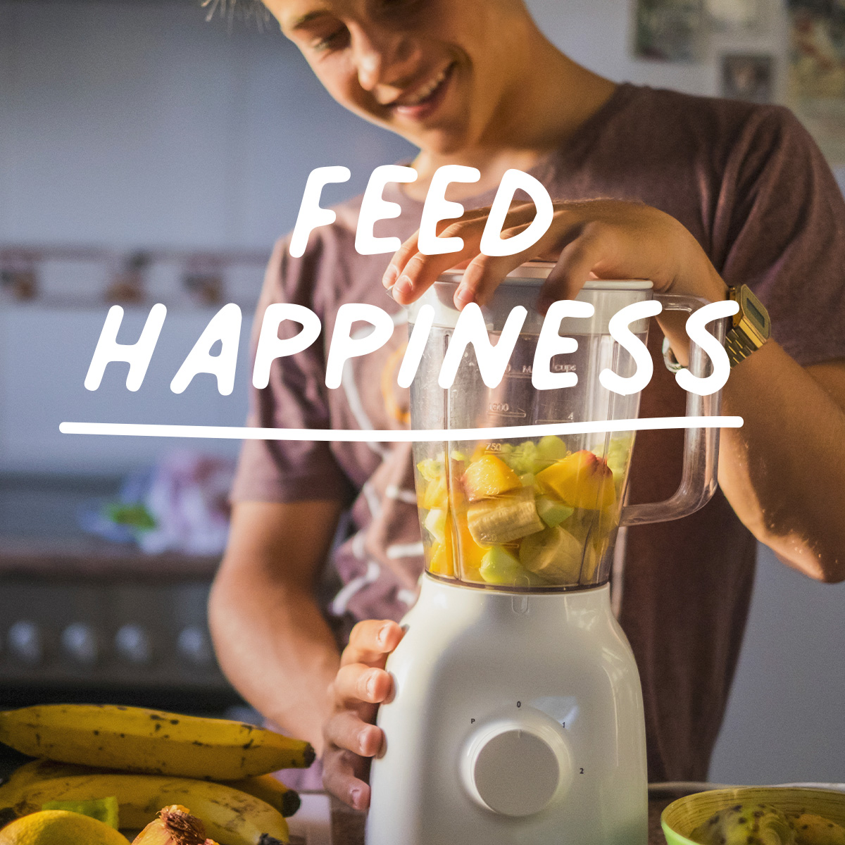 image shows young man using a blender with the words 'feed happiness' overlaying image